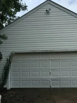 The same garage gable after washing, the vinyl back to white